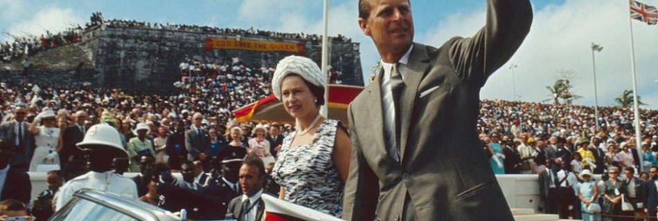 Prince Phillip and Queen Elizabeth waving at an audience. They are known for their powerful reputation.
