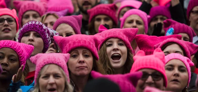 feminists in a feminism march, all wearing pink caps for symbolisation purposes