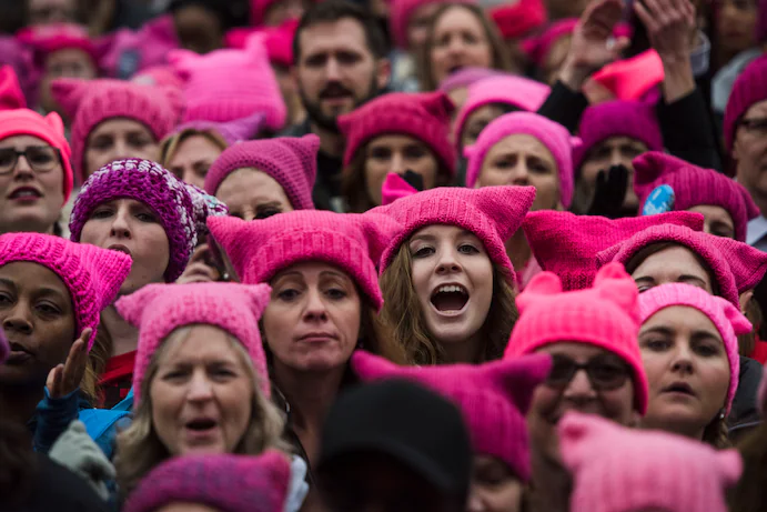 feminists in a feminism march, all wearing pink caps for symbolisation purposes